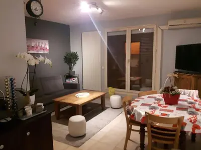 Télévision ou salle de divertissement dans l'établissement Appartement en Rez de jardin climatisée 2 pièces-cuisine avec terrasse et jardin