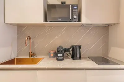 Cuisine ou kitchenette dans l'établissement Studio contemporain avec terrasse ensoleillée