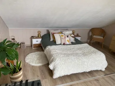Un ou plusieurs lits dans un hébergement de l'établissement Duplex bohème et lumineux avec balcon, proche Lyon