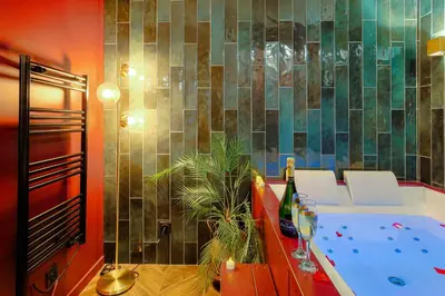 Un ou plusieurs lits dans un hébergement de l'établissement Suite jacuzzi chic et romantique climatisé