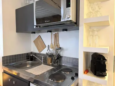 Cuisine ou kitchenette dans l'établissement Le Mur de pierre, BNB Conciergerie