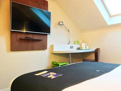Télévision ou salle de divertissement dans l'établissement Campanile Saint-Étienne Nord La Terrasse