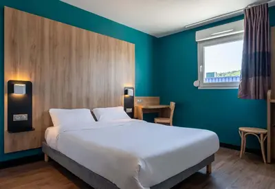 Un ou plusieurs lits dans un hébergement de l'établissement B&B HOTEL Saint-Etienne Monthieu