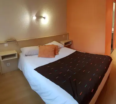 Un ou plusieurs lits dans un hébergement de l'établissement Hôtel La Bérangère