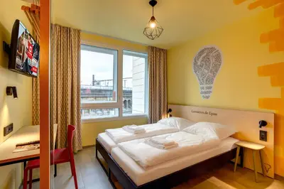 Un ou plusieurs lits dans un hébergement de l'établissement MEININGER Hotel Lyon Centre Berthelot