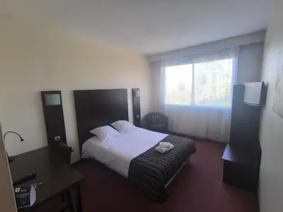 Un ou plusieurs lits dans un hébergement de l'établissement Adonis Lyon Est Hôtel Artys