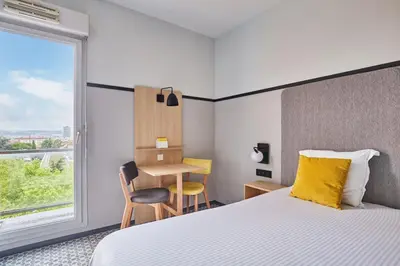 Un ou plusieurs lits dans un hébergement de l'établissement Appart'hôtel Odalys City - Bioparc Lyon Est