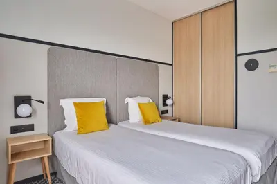 Un ou plusieurs lits dans un hébergement de l'établissement Appart'hôtel Odalys City - Bioparc Lyon Est