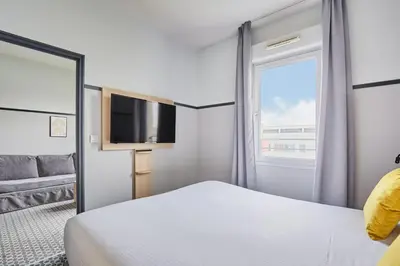 Un ou plusieurs lits dans un hébergement de l'établissement Appart'hôtel Odalys City - Bioparc Lyon Est
