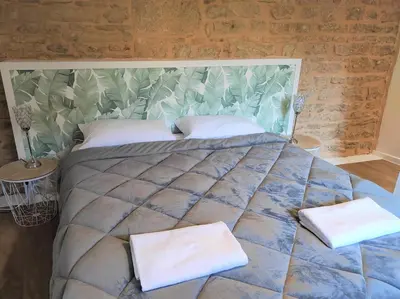 Un ou plusieurs lits dans un hébergement de l'établissement Appartement Cogny - les Meublés des Pierres Dorées